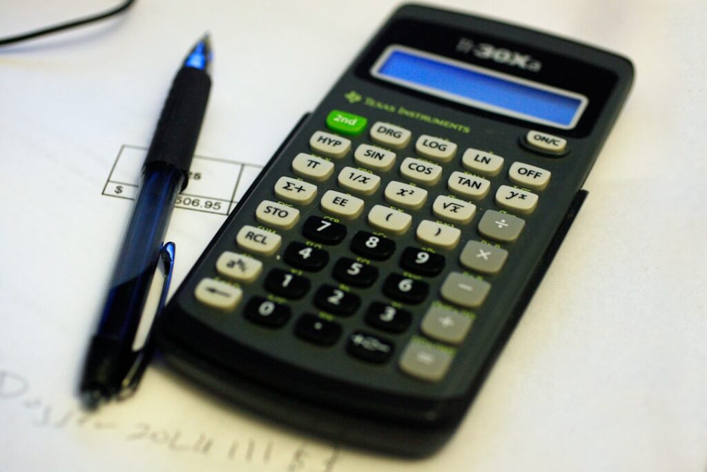 Calculator with documents and pen for evaluating SEO pricing and contract terms