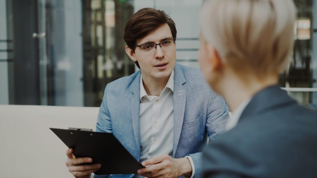 Business professional with clipboard conducting interview and asking evaluation questions